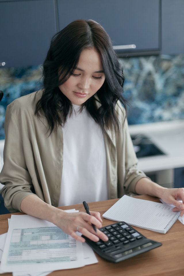 woman calculating her income with calculator woman calculating her income with calculator
